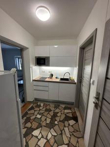 a small kitchen with a sink and a counter at Apartmány Zuzana in Primošten