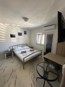 a bedroom with a bed and a table at Apartmány Zuzana in Primošten