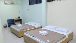 a room with two beds and a table and a chair at Susan Hotel Seafront in Sandakan +17 photos