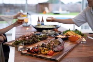 a table full of food with people holding drinks at VILLA Seamu 九十九里 家族と愛犬で楽しむサウナとプール ガラス貼りBBQルーム付き高級ガーデンヴィラ in Kujukuri +47 photos