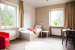 una piccola stanza con un letto e un tavolo di Haus Waldläufer a Braunlage