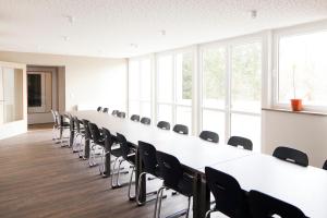 un tavolo lungo e sedie in una stanza con finestre di Haus Waldläufer a Braunlage