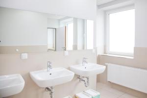 un bagno bianco con due lavandini e uno specchio di Haus Waldläufer a Braunlage Altre 19 foto