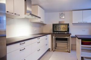 una cucina con mobili bianchi e un forno a microonde di Haus Waldläufer a Braunlage