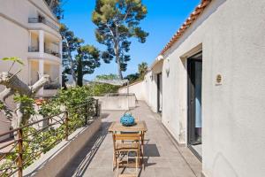 a patio with a table and chairs on a balcony at Maisonnette Saona vue mer plages 800m WiFi CLiM PK By HC in Carqueiranne