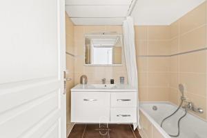 a bathroom with a white sink and a bath tub at Maisonnette Saona vue mer plages 800m WiFi CLiM PK By HC in Carqueiranne