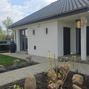 a white house with a porch and a driveway at Babie lato Łagów in Łagów