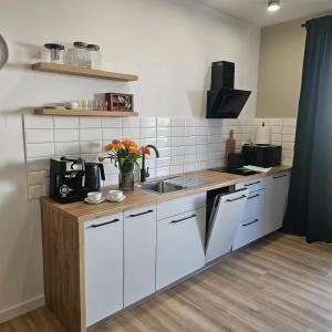 a kitchen with white cabinets and a wooden counter top at Babie lato Łagów in Łagów +5 photos