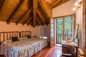 Un dormitorio con una cama y una ventana grande. en Casa El Agero, en Cabañes