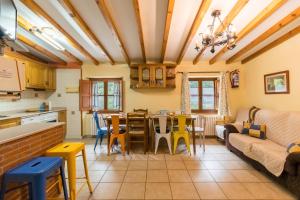 Una cocina y una sala de estar con mesa y sillas. en Casa El Agero, en Cabañes