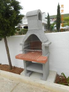 un forno per pizza seduto sopra una panca di Apartments Relax Punat a Punat