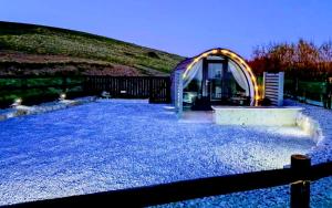 a house on a gravel yard with a building at Hillside Hideaway in Doolin