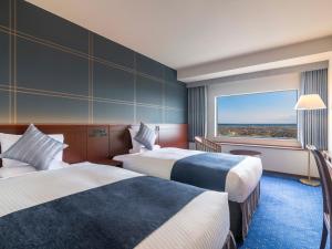 a hotel room with two beds and a large window at ART HOTEL Kashima Central in Kamisu