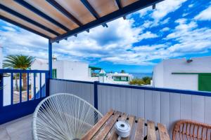 a wooden table on a balcony with a fan at Barraquito - Pool - 100M to Playa de Las Cucharas By Lanzarote Vacation Homes in Costa Teguise