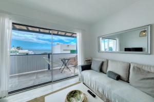 a living room with a couch and a large window at Barraquito - Pool - 100M to Playa de Las Cucharas By Lanzarote Vacation Homes in Costa Teguise