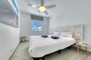 Un dormitorio con una cama grande con ventilador de techo. en Barraquito, en Costa Teguise 35 fotos más