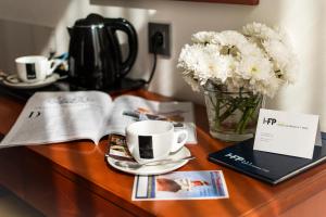 a table with a vase of flowers and a cup of coffee at Hotel de Francia y París in Cádiz