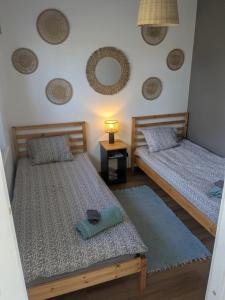 two beds in a room with a lamp on a table at Peedu saunamaja in Hiiumaa