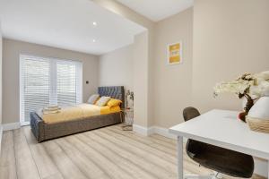 a bedroom with a bed and a desk and a window at Hammersmith Flat 2 Bedrooms LGF in London