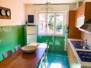 a kitchen with green walls and a wooden counter top at Romantica Dimora Bocca di Magra in Bocca di Magra