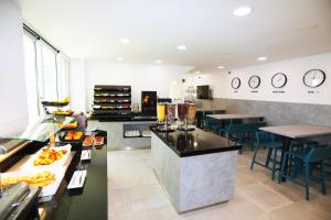 a kitchen with a counter and some tables and chairs at Hotel - Teranea City Hvar in Hvar