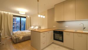 Una cocina con una cama frente a una ventana. en Angel's apartments - by Hosty, en Cracovia