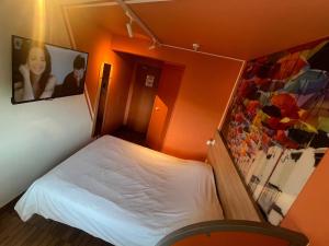 a small bedroom with a white bed in a room at Egg Hôtel Sarcelles in Sarcelles