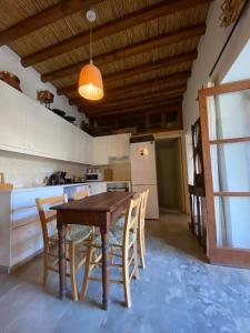 a kitchen with a wooden table and chairs and a refrigerator at Spiti Calliope in Kathikas