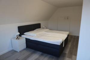 een slaapkamer met een groot bed met een zwart hoofdeinde bij Ferienwohnung MTS in Bunde