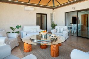 ein Wohnzimmer mit Couchtisch und Stühlen in der Unterkunft Casa del Mirador Ocean VIEW private heated pool in Playa Paraiso