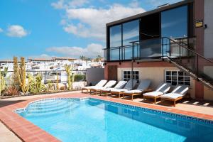 ein Swimmingpool mit Liegestühlen neben einem Gebäude in der Unterkunft Casa del Mirador Ocean VIEW private heated pool in Playa Paraiso