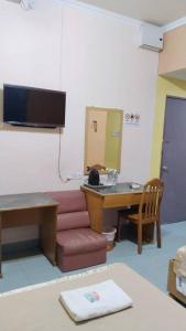 a room with a desk and a couch and a table at Susan Hotel Seafront in Sandakan