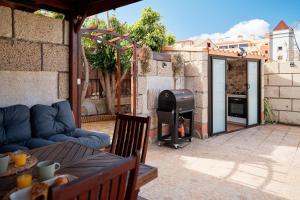 eine Terrasse mit Couch und Grill in der Unterkunft Casa del Mirador Ocean VIEW private heated pool in Playa Paraiso