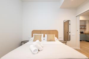 a bedroom with a large white bed with two towels at Lisboa by Concept Flats in Valencia
