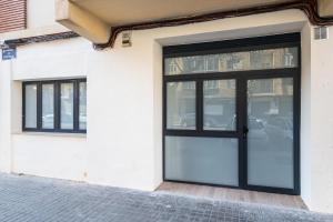 a black door on a white building with windows at Lisboa by Concept Flats in Valencia