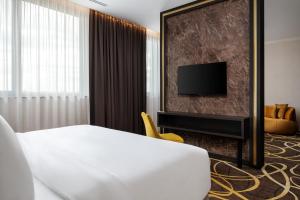 a hotel room with a bed and a tv at Card Hotel in Šamorín