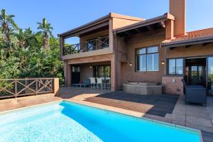 a house with a swimming pool in front of a house at San Lameer Villa 14304 - 5 Bedroom Luxury - 10 pax - San Lameer Rental Agency in Southbroom