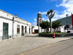 a building with a clock tower and a red fire hydrant at Casa Estrada in Caleta de Interián