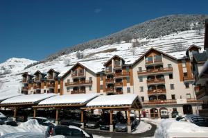 um grande edifício com neve numa montanha em Résidence Odalys L'Ouillon em Saint-Sorlin-dʼArves