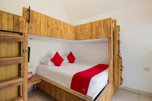 a bedroom with two bunk beds with red pillows at Capital O Hacienda Filadelfia, El Atorón, Irapuato in Irapuato