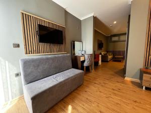 a living room with a couch and a flat screen tv at akcayzeytin otel in Akçay