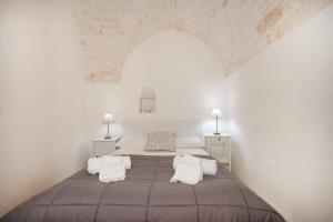Un dormitorio con una cama en una habitación blanca. en Casa Pà, en Ostuni