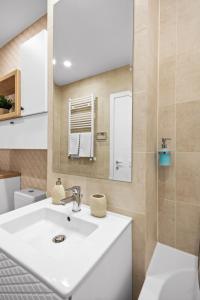 a bathroom with a white sink and a mirror at Hils Pallady Apartments in Bucharest +48 photos