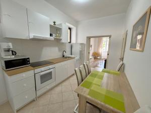 a kitchen with a table and a dining room at Apartments Del Mare in Crikvenica