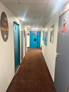 a hallway of a hospital with blue doors at Egg Hôtel Sarcelles in Sarcelles +9 photos