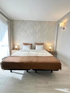 a bedroom with a large bed with two lamps on it at DonAna 308 in Lagos
