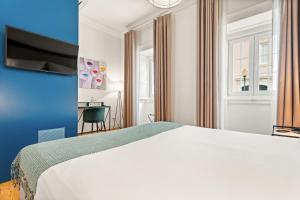 a bedroom with a white bed and a desk at Jardim da Lapa by Shiadu in Lisbon +41 photos