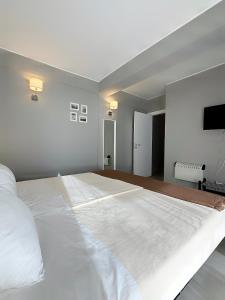 a bedroom with a large white bed with a flat screen tv at DonAna 308 in Lagos