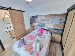 Schlafzimmer mit einem Bett mit rosa und lila Kissen in der Unterkunft Villa Cala Llarga Beach in Roses