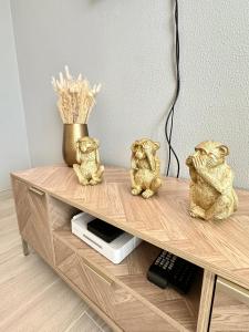 three gold bear figurines sitting on a wooden table at DonAna 308 in Lagos